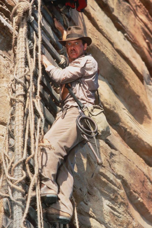 Bild 1 von 13: Die Flucht vor dem hünenhaften und brutalen Hohepriester des Shiva-Kultes ist noch nicht ganz gelungen - jetzt muss Indy (Harrison Ford) um sein Leben kämpfen, während er an einer gerissenen Hängebrücke Hunderte von Metern über einem reißenden Fluss voller Krokodile hängt ...