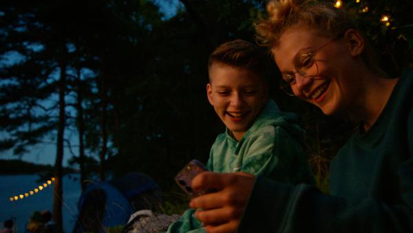 Bild 1 von 2: Romeo (Even Fjelle) und Andrine (Selma Adeline Opedal) haben Spaß bei einer Party im Wald.