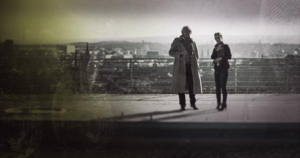 Bild 1 von 4: Bildmontage: Profiler Axel Petermann (l.) und Psychologin Katinka Keckeis (r.) stehen rechts im Vordergrund. Hinter ihnen befindet sich die Totale einer Stadt. Am rechten Bildrand gut zu erkennen gelbe Fingerabdrücke.