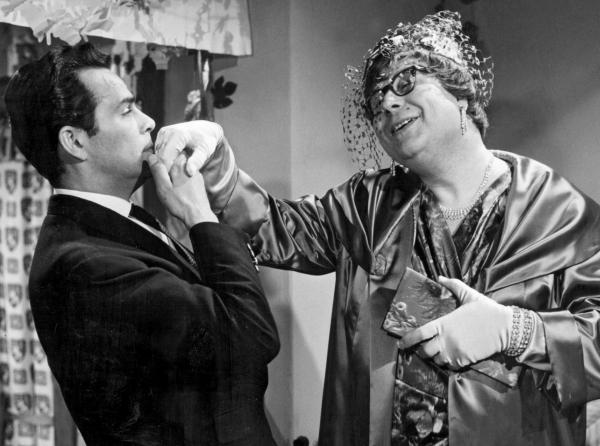 Bild 1 von 1: Damenimitator Egon Kummer (Heinz Erhardt, re.) hat sich als Frau verkleidet und spielt Rechtsanwalt Kurt Wehling (Adrian Hover) etwas vor.