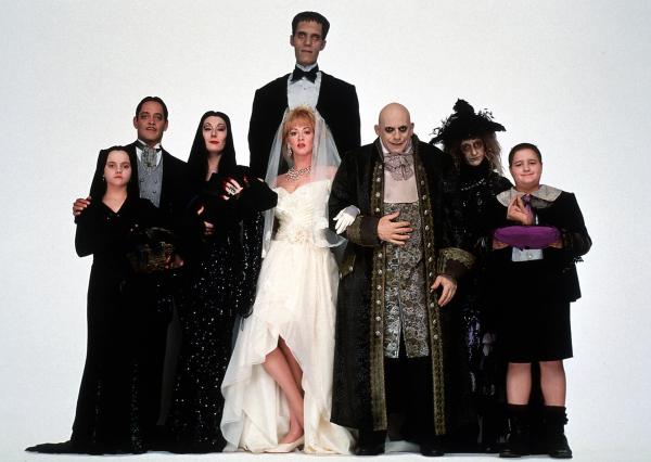 Bild 1 von 10: Die düstere Familie Addams feiert die Liebe zwischen Onkel Fester (Christopher Lloyd, 3.v.r.) und Debbie (Joan Cusack, M. vorne). Wednesday (Christina Ricci, l.), das Ehepaar Morticia (Anjelica Huston, 3.v.l.) und Gomez Addams (Raúl Juliá, 2.v.l.), Lurch (Carel Struycken, M. hinten), Großmutter (Judith Malina, 2.v.r.) und Pugsley (Jimmy Workman, l.) trauen der geheimnisvollen Debbie jedoch nicht.