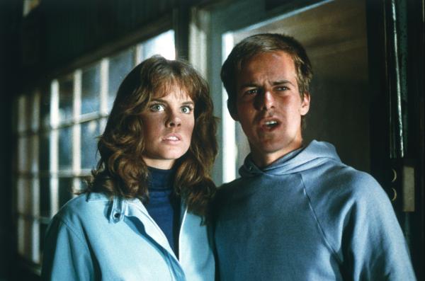 Bild 1 von 4: Leigh (Alexandra Paul) und Dennis (John Stockwell) haben einen Plan geschmiedet um Christine buchstäblich platt zu machen. In einem Lagerhaus finden sie eine alte Planierraupe, mit der sie das Auto ein für alle mal los werden wollen.