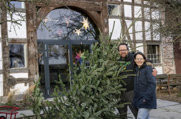 Bild 1 von 4: und ihr Mann Marius stellen draußen einen Weihnachtsbaum auf.