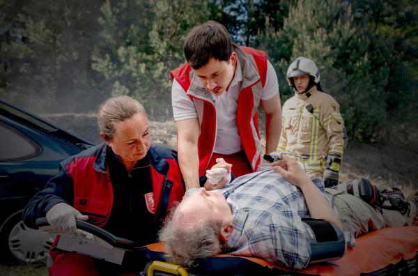 Bild 1 von 4: Paul (Paul Zichner, M.) und Janin (Gabriele Völsch, l.) kümmern sich um einen Verletzten.