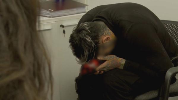 Bild 1 von 2: Ein junger Mann wird nach seiner Rückkehr aus den USA befragt - die Begegnung mit der Realität seiner Abschiebung hinterlässt sichtbare Spuren.