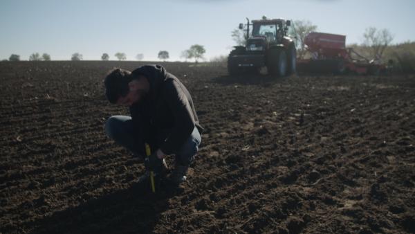 Bild 1 von 15: Landwirt Phillip Krainbring kontrolliert, ob das Saatgut tief genug in der Erde liegt.