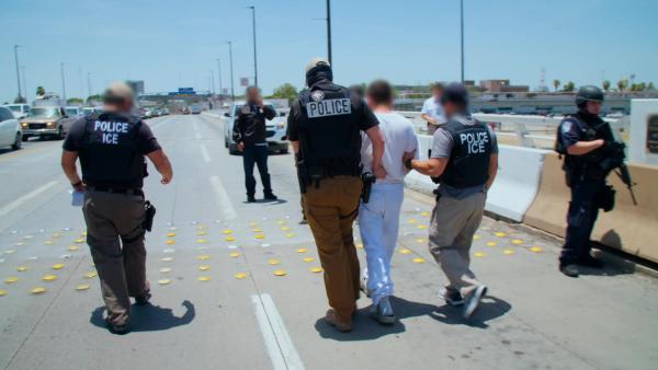 Bild 1 von 2: Auf der Brücke treffen US-amerikanische Beamte an der Grenze auf die mexikanischen Behörden, um einen Gesuchten zu übergeben.