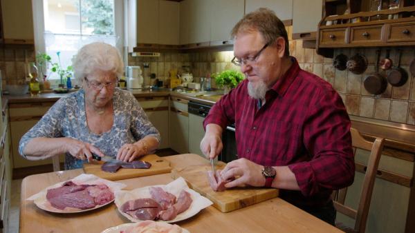 Bild 1 von 9: Lore Huber und ihr Sohn Uli schneiden verschiedene Fleischsorten für die Milzwurst auf.