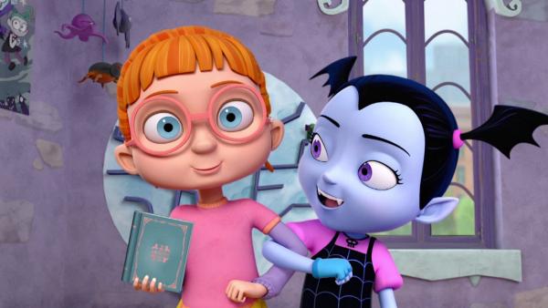 Bild 1 von 11: a) Als sich Vampirina und ihre Familie das Fledermausfieber einfangen, versuchen Demi und Gregoria, einen heilenden Trank zu brauen. b) Vampirina hilft Bridget, für den Gedichtetag zu üben.