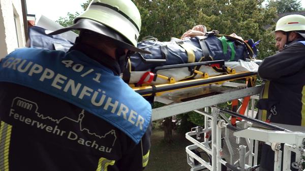 Bild 1 von 3: Die Feuerwehr Dachau hilft mit einer Drehleiter einem Patienten