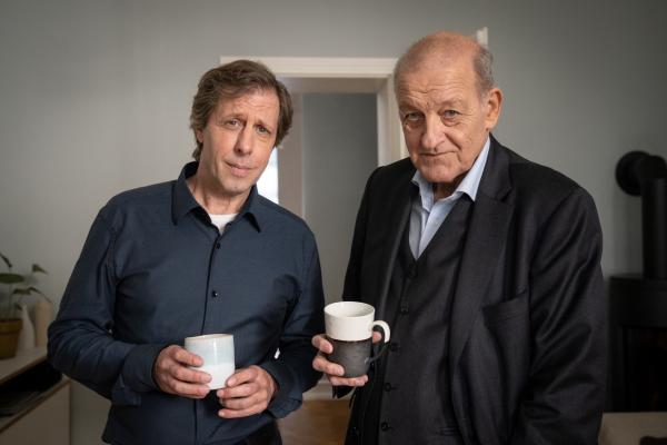 Bild 1 von 15: In Anna Springers Wohnung gönnen sich Wilsberg (Leonard Lansink, r.) und Ekki (Oliver Korittke, l.) eine Tasse Kaffee.