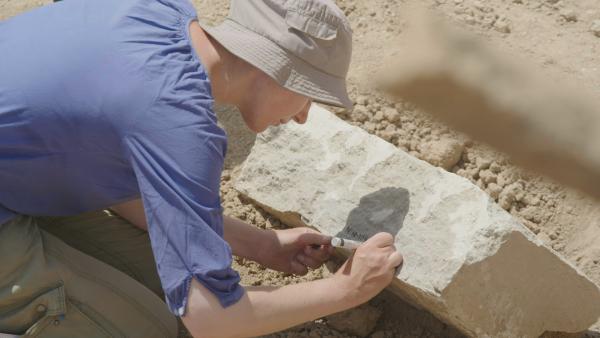 Bild 1 von 8: Ulrike Buerger writes on a newly uncovered stone slab in Mosul, Iraq. (Windfall Films/Ali Hilal Ali Hussain)