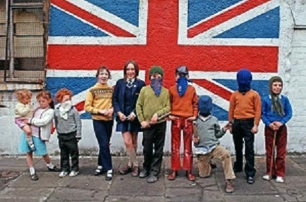 Bild 1 von 3: Kinder aus einem Viertel protestantischer Unionisten in Belfast vor einem Wandbild mit der Flagge des Union Jack, Nordirland, 1971