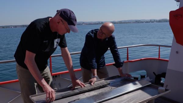 Bild 1 von 2: Dr. Martin Wessels (links) vom Institut für Seenforschung in Langenargen zeigt Karsten Schwanke einen Sedimentbohrkern vom Grund des Bodensees aus 160 Metern Tiefe. Damit rekonstruiert der Forscher die Geschichte des Sees.