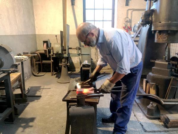 Bild 1 von 11: Im Bild: Hubert Winkler, Kunstschmied, Pfarrwerfen beim Schleifen am Schleifstein (Axt).