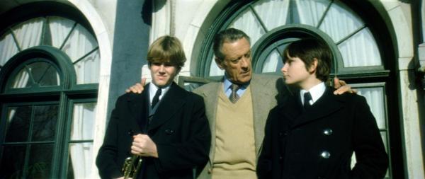 Bild 1 von 6: Der Firmenboss Richard Thorn (William Holden, M.) verabschiedet seinen Sohn Mark (Lucas Donat, l.) und seinen Neffen Damien (Jonathan Scott-Taylor, r.), für die nun der Ernst des Lebens auf der Militärschule beginnt ...