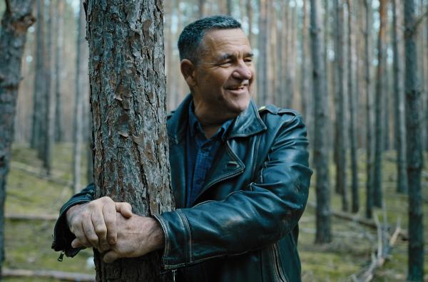 Bild 1 von 7: Mike Klein zeigt wie der mutmaßliche Mörder Wolfgang Schmidt damals von Polizisten mit Handschellen am Baum fixiert wurde. (nachgestellte Szene)