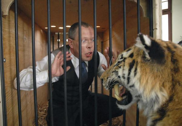Bild 1 von 7: OB Herrenbrück (Frank Sieckel) hat aus Versehen den Tiger aus seinem Käfig entkommen lassen. Um sich zu schützen sucht er nun selbst Zuflucht hinter Gittern. Da der OB keinen Kontakt mit der Außenwelt aufnehmen kann, muss er nun bis zum anderen Morgen in dieser misslichen und zugleich gefährlichen Lage ausharren.