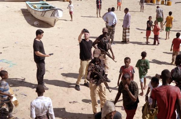 Bild 1 von 4: Die Kriegstouristen Andrew und AJ werden in Somalia am Strand von privaten Bodyguards bewacht.
