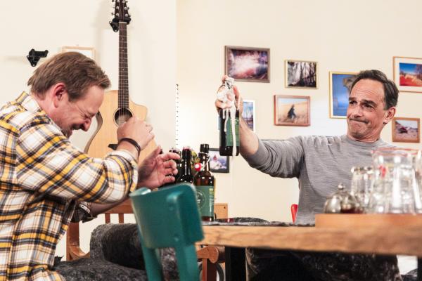 Bild 1 von 5: Mike (Harry Blank, rechts) öffnet die geschüttelte Bierflasche und trifft mit dem Schaum auch Gregor (Holger Matthias Wilhelm, links).