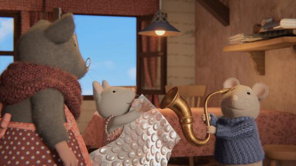 Bild 1 von 4: Julia (M.) und Sam (r.) haben herausgefunden, was die laute Knallerei im Mäusehaus verursacht hat. Das Platzen von Blasen einer Luftpolsterfolie verstärkt durch Oma Goudas (r.) Hörrohr. Beiden macht es Spaß, das Ganze selbst auszuprobieren.