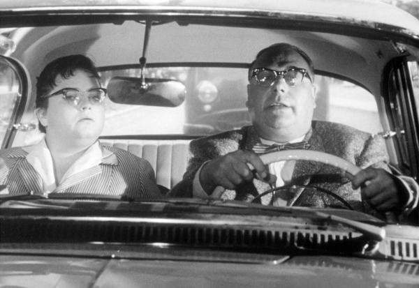 Bild 1 von 1: Verkehrspolizist Eberhard Dobermann (Heinz Erhardt) nimmt Fahrstunden bei der Fahrlehrerin (Trude Herr).