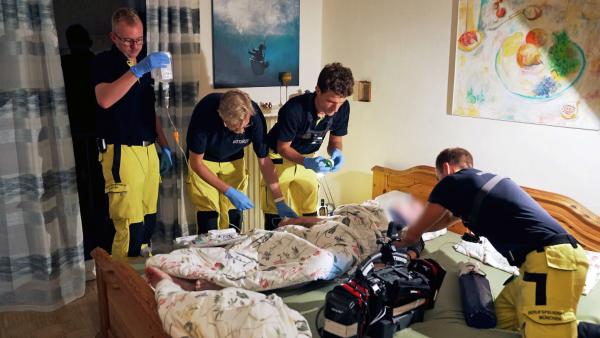 Bild 1 von 3: Notärzte der Feuerwehr München kümmern sich um einen Patienten