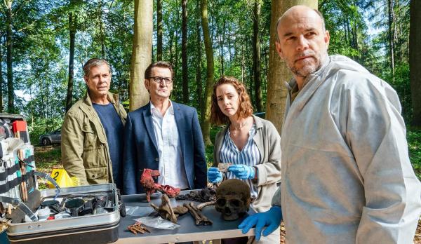 Bild 1 von 5: Im Bild: Am Fundort der Leiche werden Finn Kiesewetter (Sven Martinek, l.) und Lars Englen (Ingo Naujoks, 2.v.l.) schon von Ida Müller-Dogan (Amelie Plaas-Link, 2.v.r.) und Rechtsmediziner Dr. Henning Strahl (Christoph Tomanek, r.) empfangen.