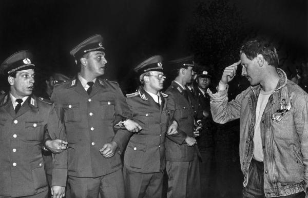 Bild 1 von 2: Volkspolizisten versperren am Abend des 40. Jahrestages der DDR Demonstranten den Weg.