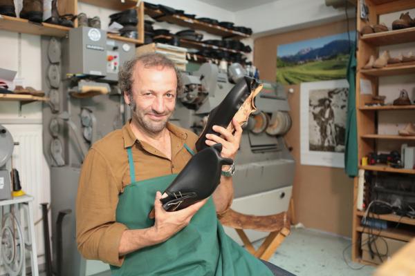 Bild 1 von 5: Beim Schuster im Allgäu baut Schmidt Max einen Haferlschuh. Ein Hand-Werk im Wortsinn, denn nicht der Kleber, sondern die Ahle ist das wichtigste Werkzeug in der traditionellen Werkstatt. Fünf Tage sind Anfänger mit dem Anfertigen eines Maßschuhs beschäftigt. Und das kostet Kraft, denn der mit Schusterpech bestrichene Faden muss durch schnelle Verarbeitung warm und geschmeidig gehalten werden.
