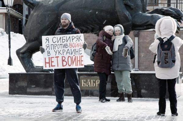 Bild 1 von 7: Der Blogger und Aktivist Egor Lesnoy protestiert am 27. Februar 2022 in Irkutsk gegen den russischen Angriffskrieg gegen die Ukraine. Gleichzeitig posieren Passanten vor dem \