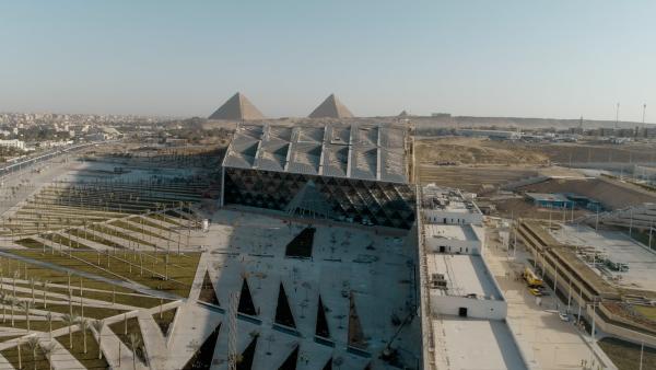 Bild 1 von 8: Blick von oben auf das Grand Egyptian Museum mit den Pyramiden im Hintergrund.