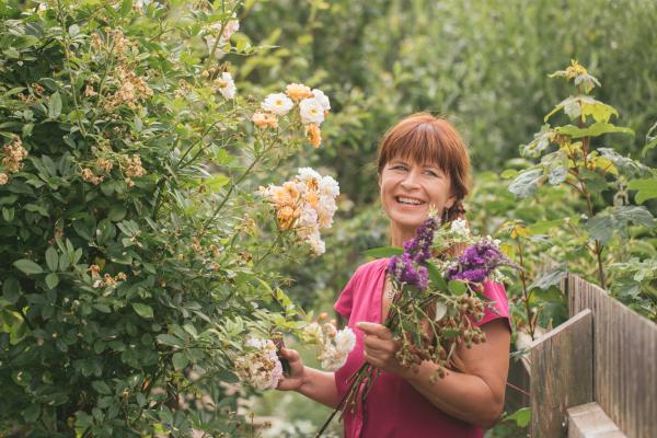 Bild 1 von 3: Moderatorin Sabrina Nitsche beim Schneiden eines sommerlichen Blumenstraußes im Querbeet-Garten.