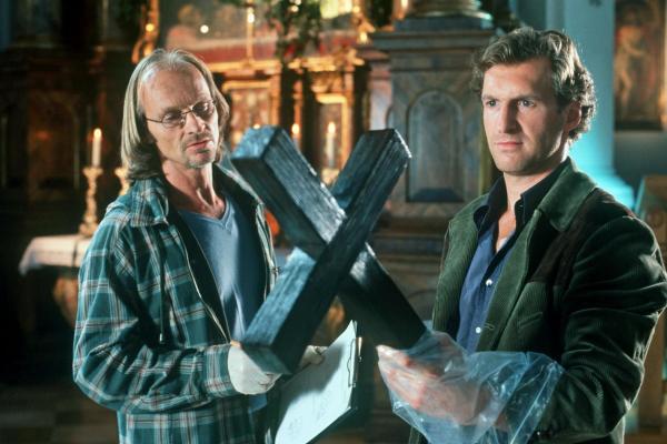 Bild 1 von 8: In der Murnauer Kirche wird eine Anwältin ermordet. Dr. Jahn (Eisi Gulp, l.) und Mark (Siegfried Terpoorten, r.) untersuchen die Mordwaffe, das Holzkreuz...