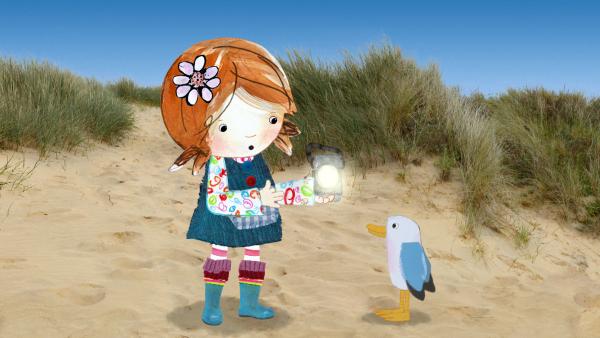Bild 1 von 6: Lily und Pelle haben eine Kurbellampe am Strand gefunden und überlegen, was man damit anstellen kann.