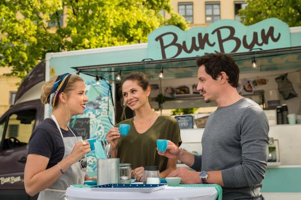 Bild 1 von 15: Anna (Ellenie Salvo Gonzalez, M.) führt mit Sophie (Merle Collet, l.) etwas im Schilde. Ihr Chef Sven (Markus Brandl) ist ahnungslos.
