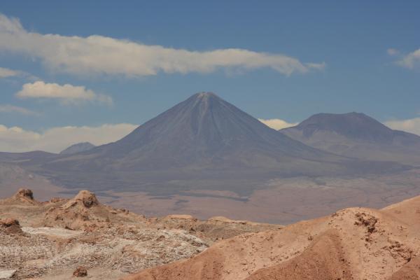 Bild 1 von 4: In der Ferne der Atacama Wüste ragen die Gipfel der Anden auf. Die riesigen Vulkane von 5.000 Metern Höhe lassen ahnen, welche Kräfte hier unter der Erde wirken.