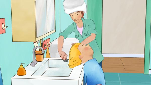 Bild 1 von 4: Mama kämmt Conni mit dem Läusekamm. Durch das Läusemittel sind die Läuse abgestorben und fallen ins Waschbecken.