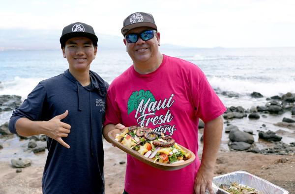Bild 1 von 6: Gemeinsam mit Sohn Tai (li.) bereitet Koch Kyle Kawakami (re.) direkt am Strand von Maui ein traditionelles Mahl mit frischem, selbst gefangenem Fisch und regionalen Zutaten zu.