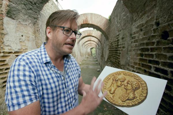 Bild 1 von 4: Archäologieprofessor Kevin Dicus mit einer Münze aus dem ersten Monat von Neros Regierungszeit, die den Kaiser mit seiner Mutter Agrippina zeigt.