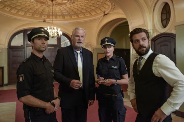 Bild 1 von 9: Mattes (Matthias Schloo, l.) und Melanie (Sanna Englund) befragen Konrad Grimm (Sebastian Kowski, 2.v.l.) und dessen Angestellten Magnus Brennecke (Christoph Jöde, r.) wegen der Diebstähle in Grimms Club.