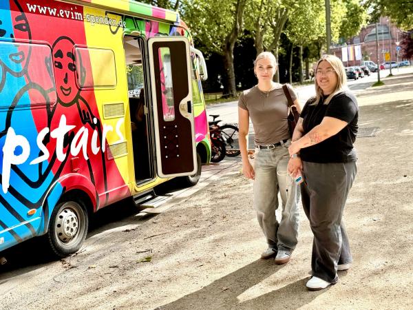 Bild 1 von 6: Anna Lena (l.) mit Teamkollegin Trucy (r.) vor dem Upstairs-Bus, einer mobilen Anlaufstelle für Jugendliche in Not.