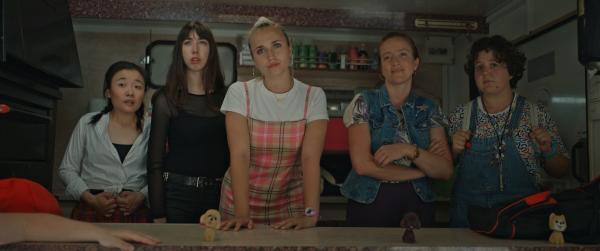 Bild 1 von 9: Ein Polizist findet heraus, dass Harry Pod'Couilles (Yilin Yang, l.), Absinthe-ni-touche (Suzanne de Baeque, 2.v.l.), Lola Bouvier (Chloé Jouannet, M.), Booby Mercury (Allison Chassagne, 2.v.r.) und Marie-Josée (Salomé Diénis Meulien, r.) in einem Food-Truck nach Paris fahren. Können ihm die Derby Girls entkommen?