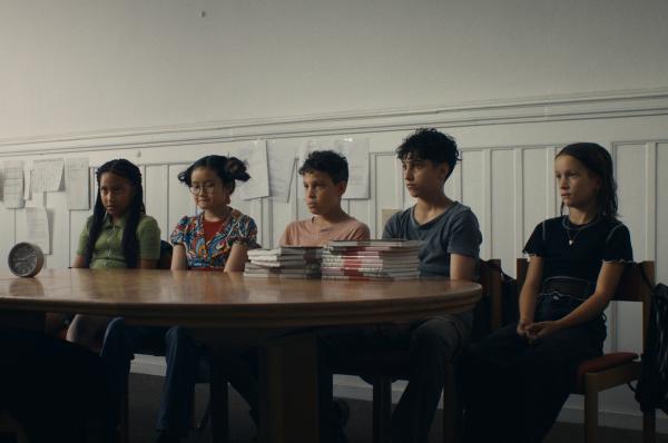 Bild 1 von 8: Fünf durchnässte Schulkinder (v.l.n.r.) - Milli (Marie Ngando), Châu (Ngoc Nhi Ha Tran), Tom (Noah Bailey), Pit (Metkan Kalan) und Liv (Marie Wahl) - sitzen bei der Direktorin, weil sie alle im Schulkeller waren als der Feueralarm losging. Keiner von ihnen will zugeben, wer für den Alarm verantwortlich ist.