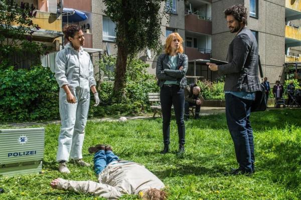 Bild 1 von 12: Eine Leiche, die scheinbar vom Himmel fiel? Elena (Annika Ernst, M.) und Kirsten (Haley Louise Jones, l.) stehen vor einem Rätsel, während Einstein (Tom Beck, r.) natürlich sofort mit einer abstrusen Idee aufwartet ...