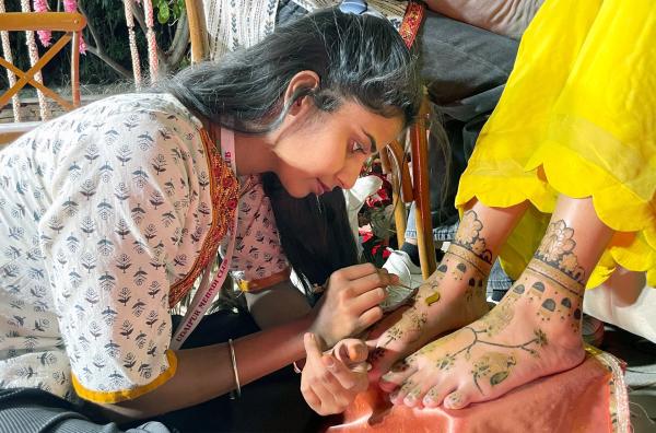 Bild 1 von 2: Körperkunst in Indien: Urmila Vaishnav bemalt die Füße der Braut mit Henna.