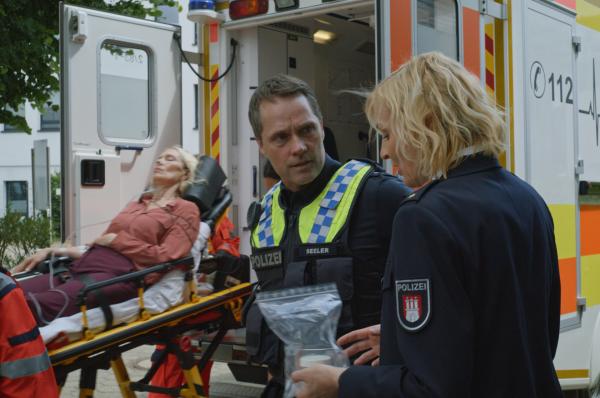 Bild 1 von 7: Mattes (Matthias Schloo, M.) und Melanie (Sanna Englund, r.) vermuten, dass die Moderatorin Karin Sievers (Katja Weitzenböck, l.) mit ihrem Tee vor laufender Kamera vergiftet wurde.