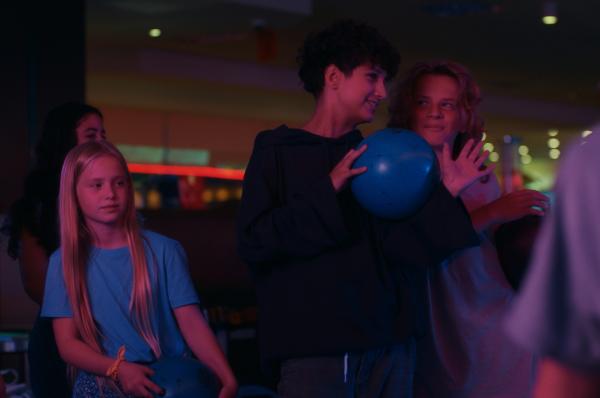 Bild 1 von 5: Eben war Pit (Metkan Kalan, M.) beim Umziehen der Schuhe noch etwas wehmütig. Doch Liv konnte ihn aufmuntern und nun wird Bowling gespielt. Zusammen mit Sunny (Leni-Sofie Rocek, l.) und Rod (Laszlo Chiesura, r.) bereitet Pit sich auf den nächsten Wurf vor.