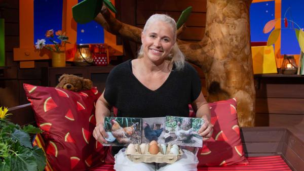 Bild 1 von 3: Singa bekommt ein Video, in dem ihr Hühner gezeigt werden. Sie erklärt, wie man erkennen kann, welches Ei von welchem Huhn gelegt wurde.