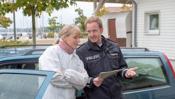 Bild 1 von 7: Kriminaltechnikerin Roswitha Prinzler (Silke Matthias, l.) und Timmermann (Mathias Junge, r.) werfen nur allzu gerne mal einen Blick in die Gästeliste der Yachtgala. Der Tote hat sich sicher auf Wismars gesellschaftlichem Parkett bewegt und sich auch im Ausland als Zahnarzt ehrenamtlich engagiert. Doch wo hat er sich Feinde gemacht? Findet sich sein Mörder etwa unter der erlauchten Gesellschaft?